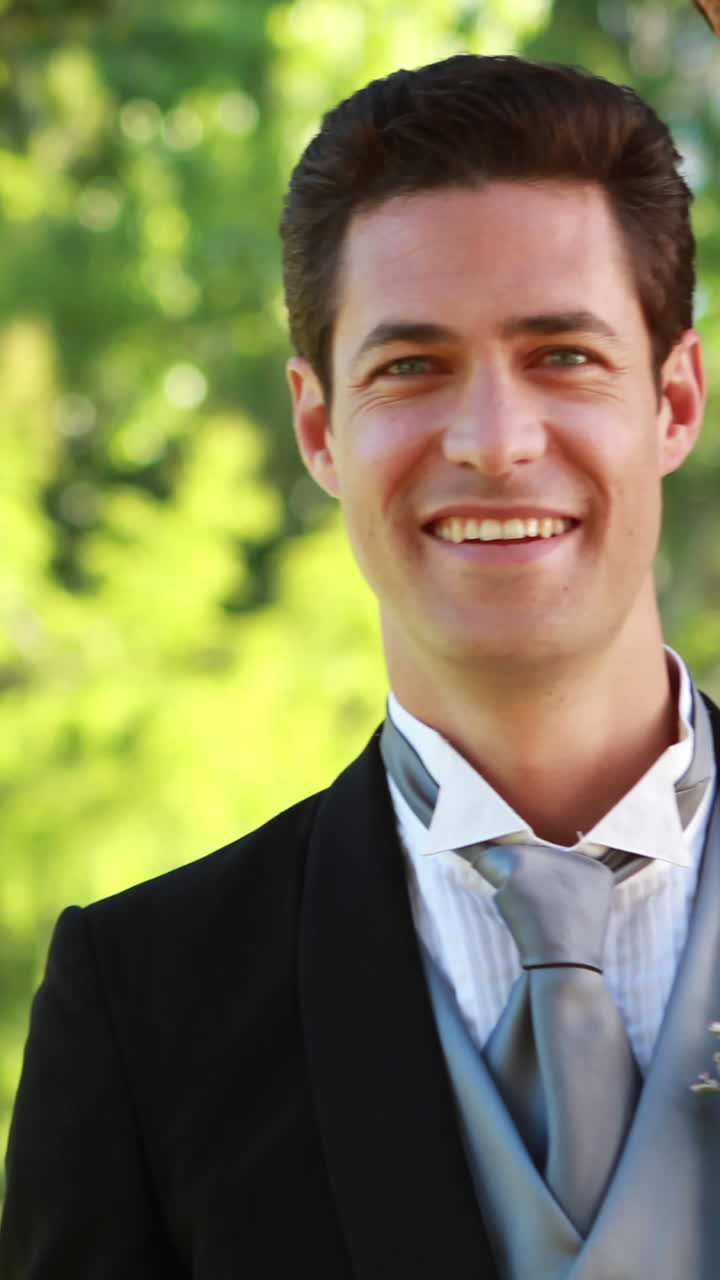 행복 한 신랑 이 카메라 에 미소 짓고 있다