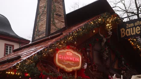 Cartel-De-Neón-De-Vino-Caliente-En-Un-Chalet-De-Madera-En-Heidelberg,-Alemania,-En-Un-Festivo-Mercado-Navideño-En-Europa