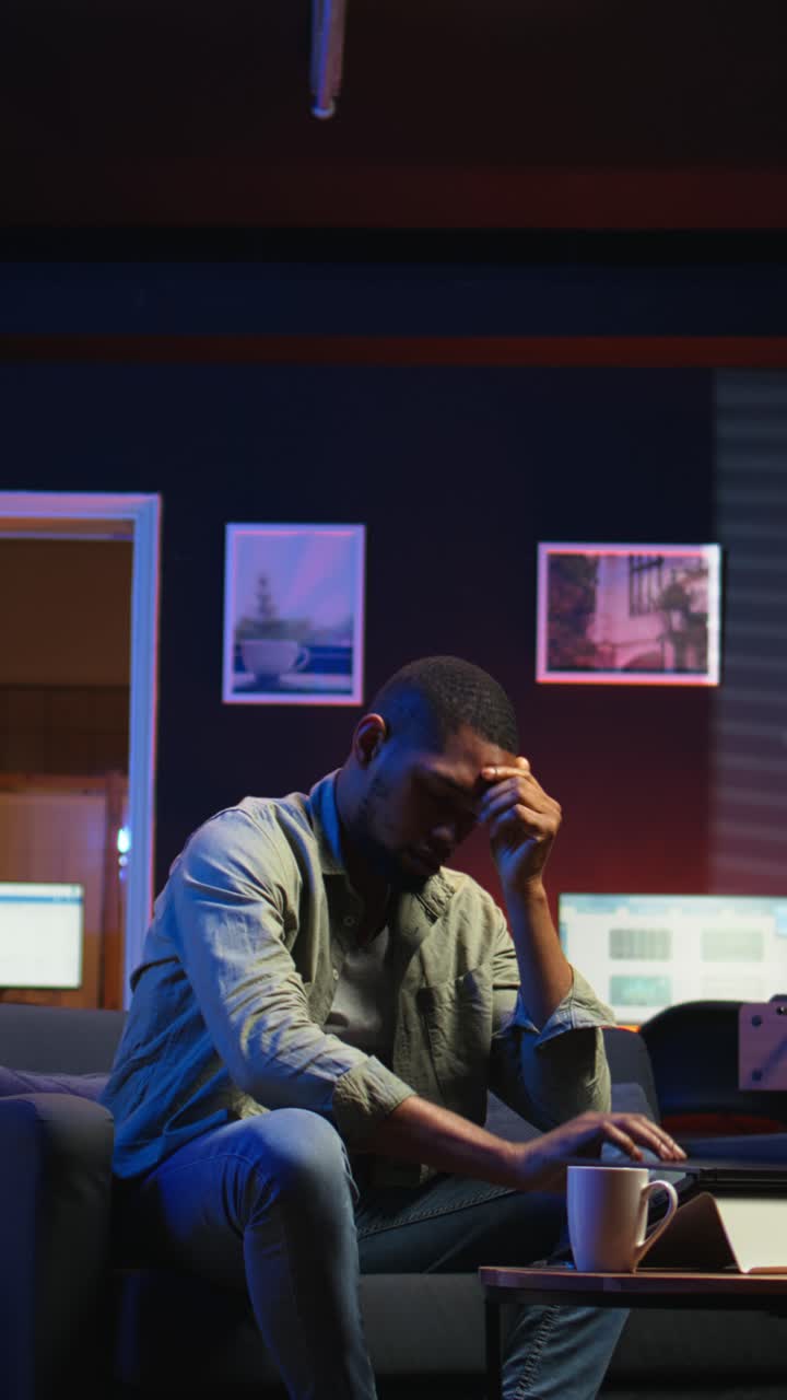 Vertical Video Tired black man failing some tasks and struggling to focus at home