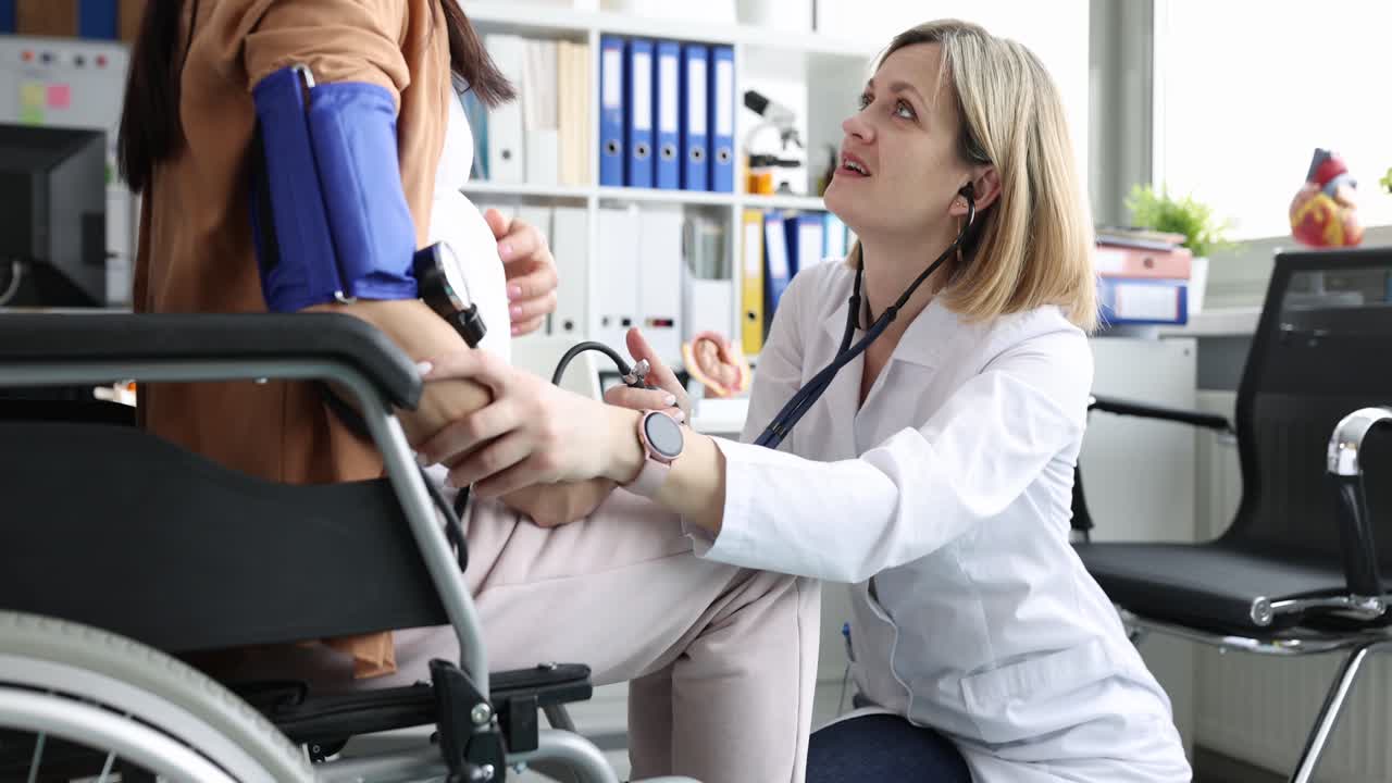 Donna incinta seduta su una sedia a rotelle nell'ambulatorio medico