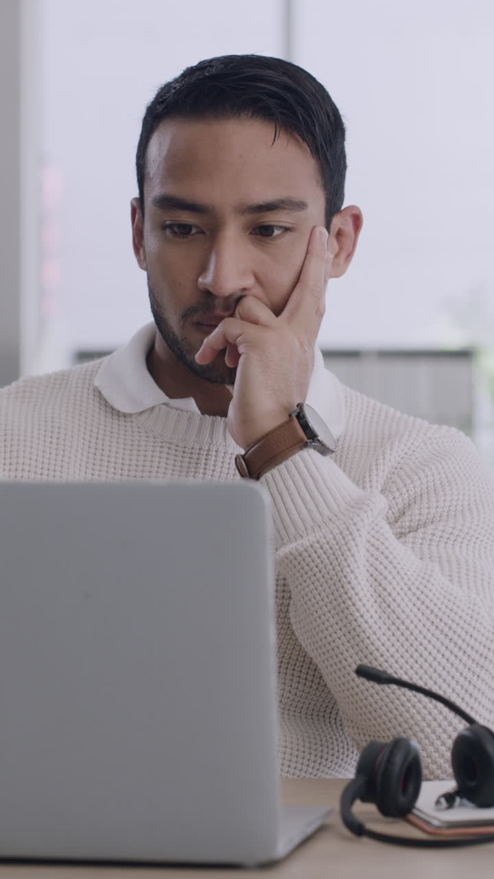 Stressed Man Experiencing Headache While Working on Laptop in Office