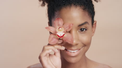 close up beauty portrait beautiful african american woman playfully touching body with orchid flower caressing healthy skin complexion enjoying gentle fragrance of natural essence skincare concept
