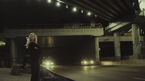 Alone-girl-standing-highway-looking-at-cars-passing-through-driving-tunnel.