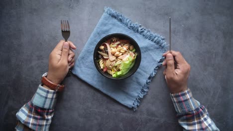 pasta salad in a bowl with fork and knife