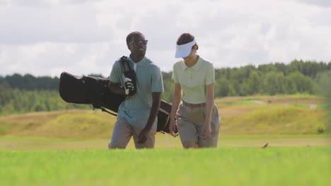 caucasian woman and african american man on the golf course.