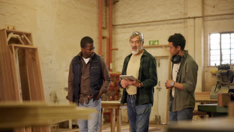 three men in a woodworking workshop