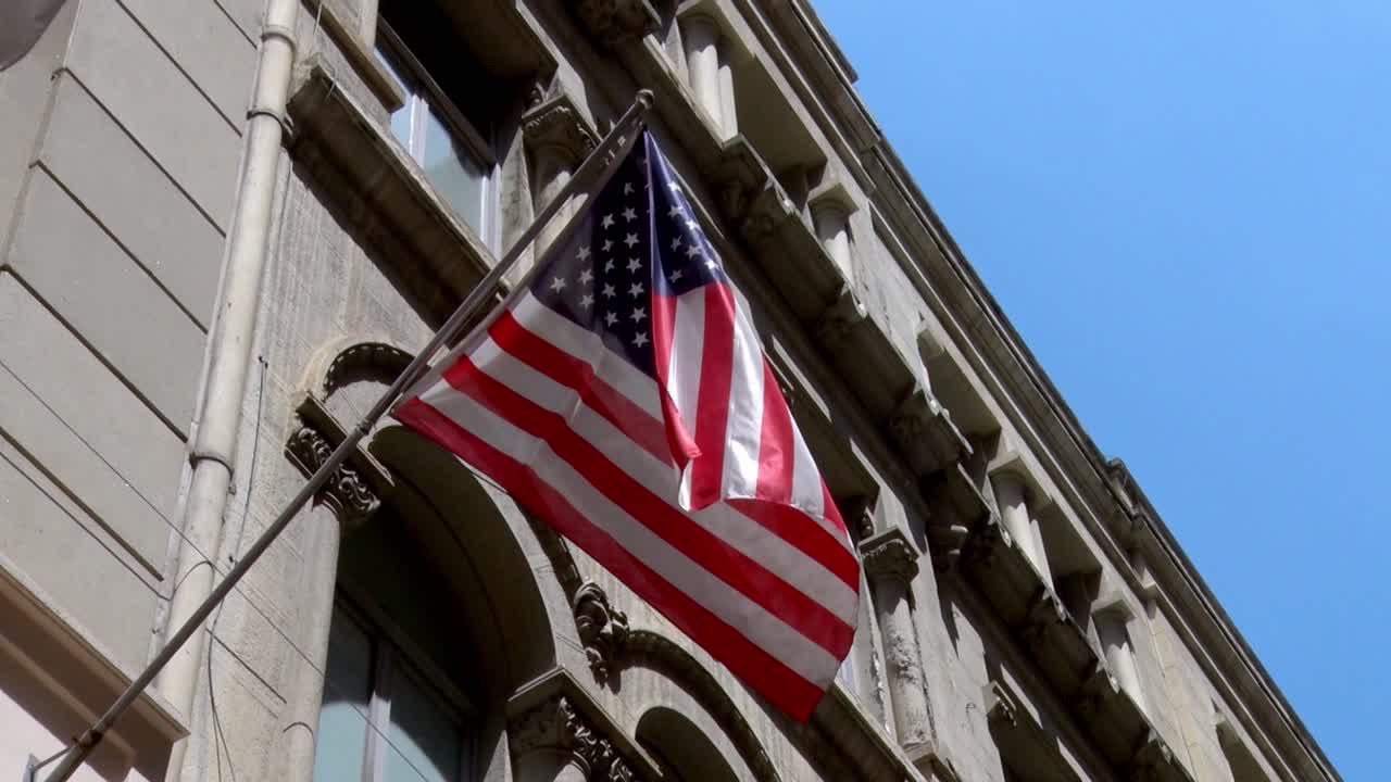 USA Stars and Stripes Flag flying off the side of a building fluttering in the breeze