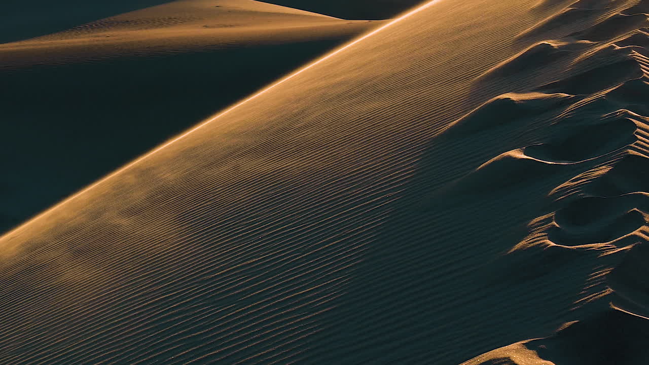 hermosa arena en cámara lenta soplada por el viento en la cima del desierto de dunas de arena