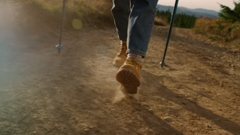 Woman-in-hiking-boots-walking-on-mountain-road