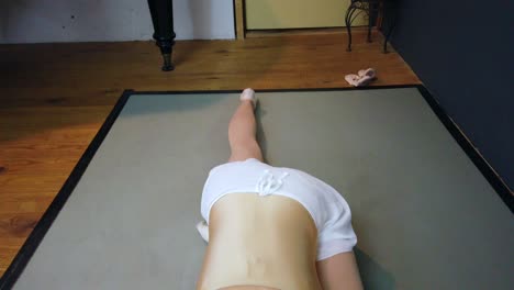 brazos abiertos con la cara hacia el suelo tiro suave y mantecoso de una bailarina con falda blanca y cuerpo dorado en cámara lenta foto video filmación en berlin urban ballet studio 2022