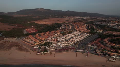 drone-aerial-video-dolly-out-on-city-complex-in-Algeciras,-Spain-with-view-on-mountains-surrounding-city-during-sunrise