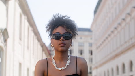 young elegant african woman walking down the street