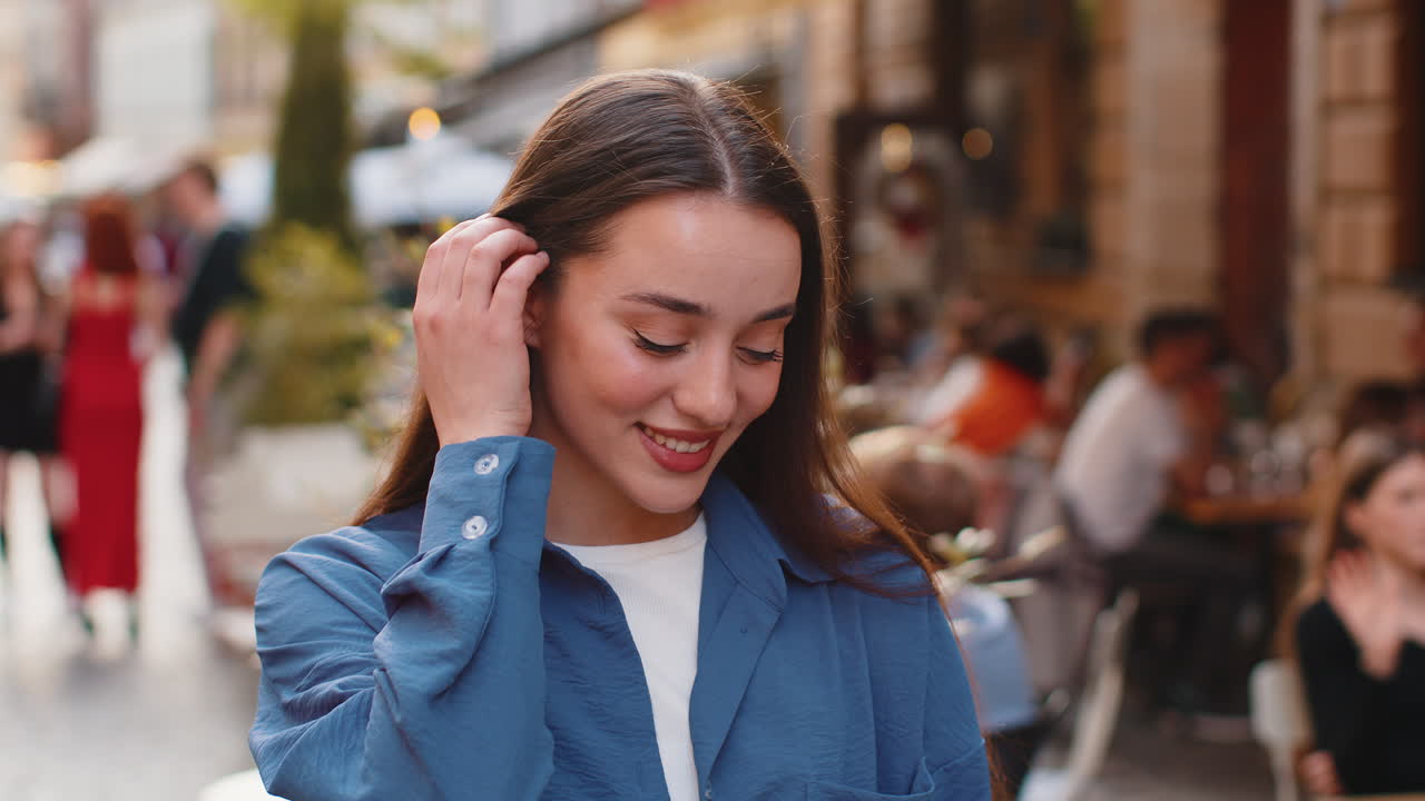 feliz mujer joven sonriendo mirando lejos soñando descansando buenas noticias sentirse satisfecho en la calle de la ciudad