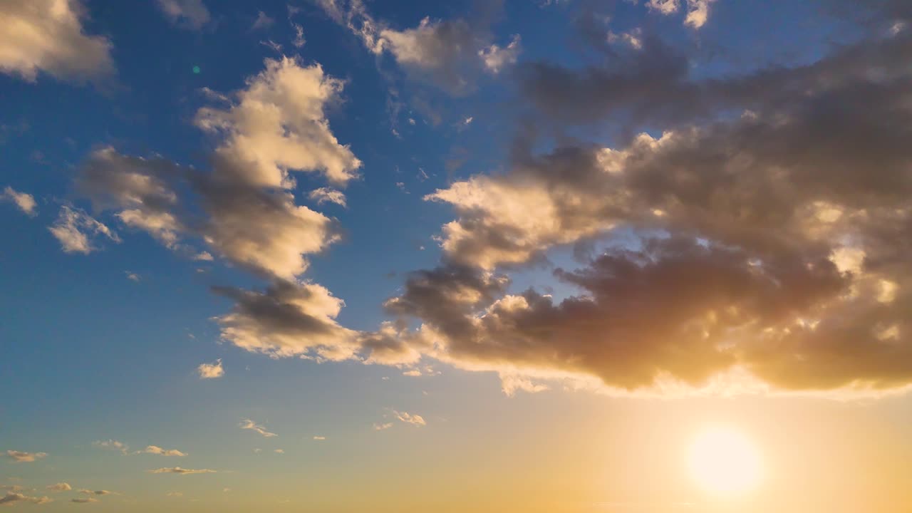 A serene sunrise with clouds moving across a vibrant sky, creating dynamic lighting and a peaceful atmosphere