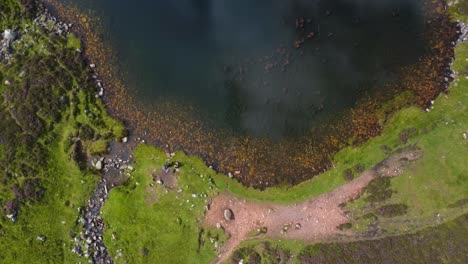 Aerial-video-of-small-lake-with-very-clear-water-and-reflections-of-clouds---Blueberry-Tarn,-Lake-District