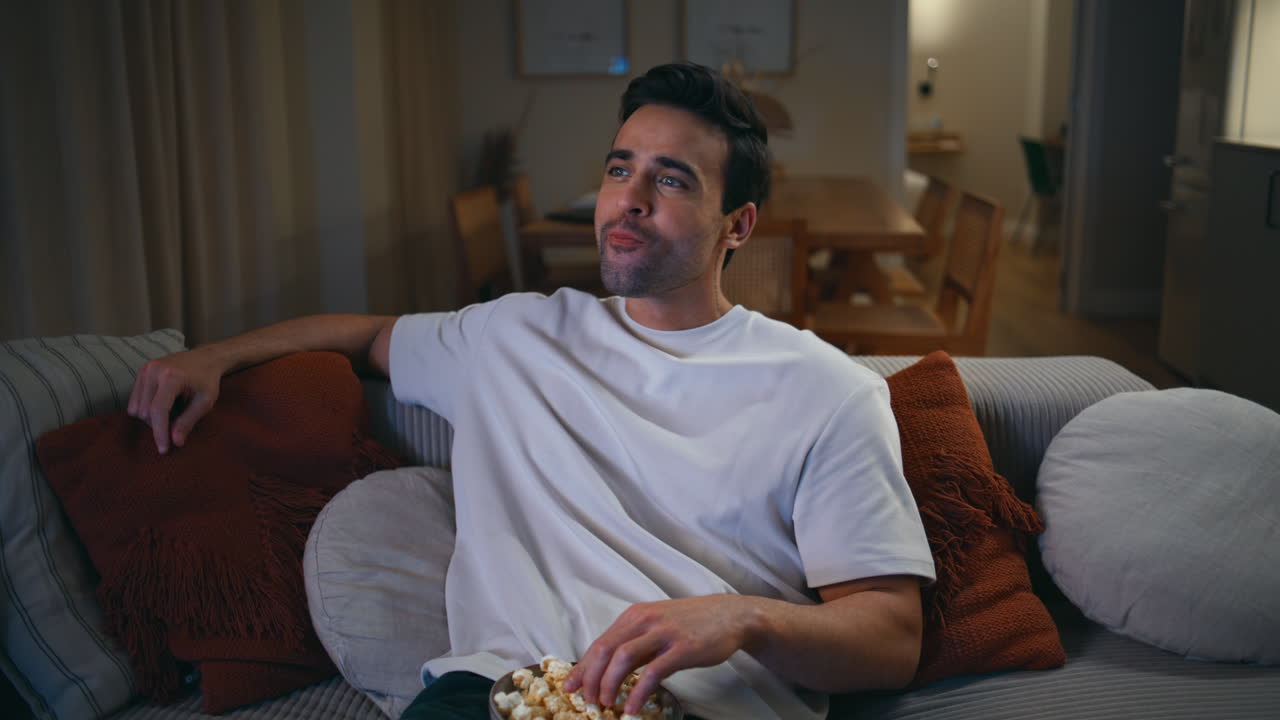 Viewer laughing comedy show on TV sitting cozy couch closeup. Man watching movie