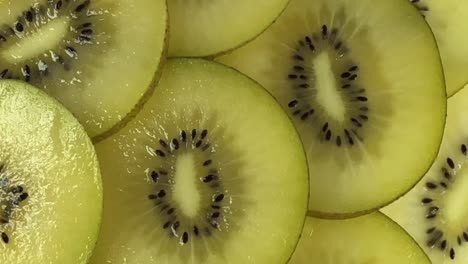 las rebanadas de frutas de kiwi girando. vista superior. con ruido y fondo de bokeh enterrado.