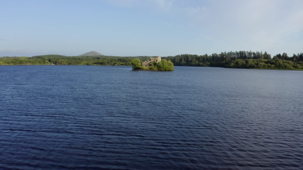 Ballynahinch Lake, Connemara, County Galway, Ireland, July 2021. Drone faces south-east while gradually pushing towards and over a small island with a ruined building