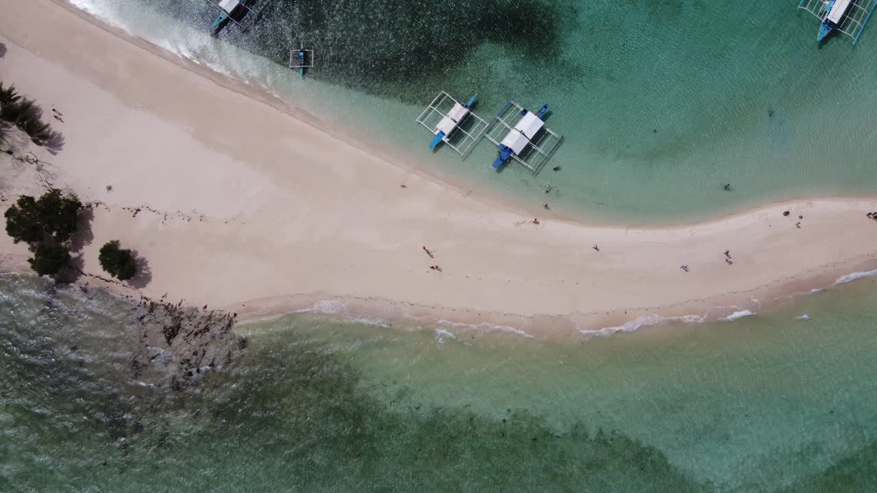 필리핀 코론 의 디타이타이안 섬 에 있는 사람 들 이 푸른  ⁇ 은 물 에서 섬 을 뛰어다니는 배 들 과 함께