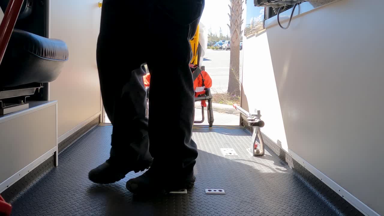 emt sweeping out back of ambulance viewed from near floor
