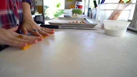 food worker rolls out cheese into sticks