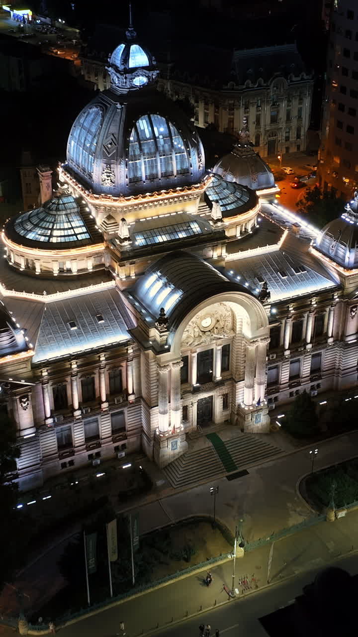 Aerial drone view of the Palace of the Deposits and Consignments illuminated in Bucharest, Romania at night. Vertical