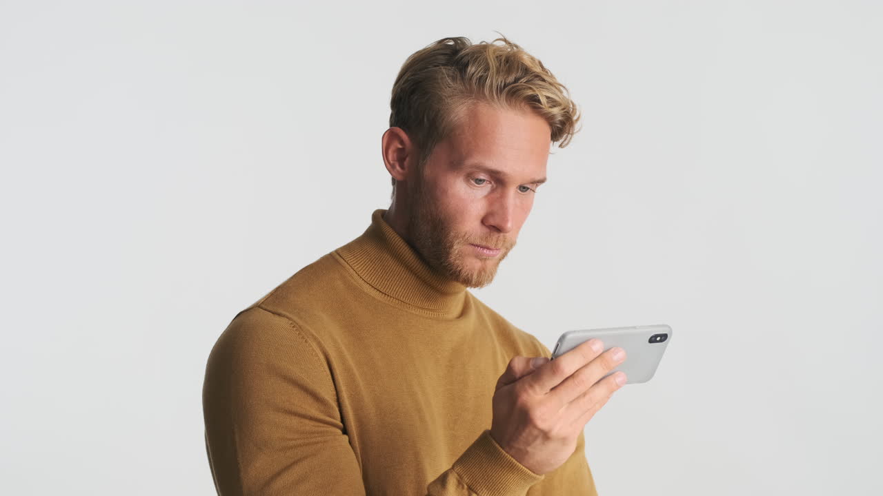 행복한 남자가 전화로 비디오를 보고 있습니다.