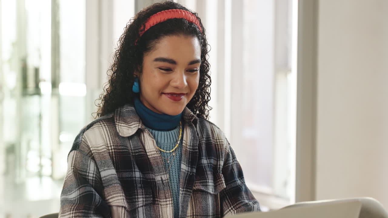 Mulher sorrindo com cabelo cacheado e camisa xadrez