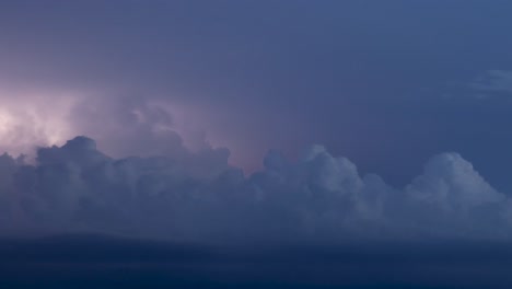 lightning and storm clouds over a hilly landscape