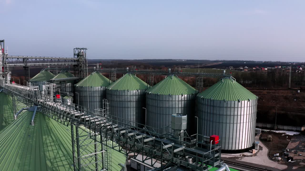 silos metálicos en el campo vista aérea. grandes contenedores para el almacenamiento y procesamiento de granos. ascensores de grano de plata en tierras de cultivo. tanque de almacenamiento vista desde arriba. silo con grano.