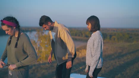 couple spends time at camp on steep river bank in evening