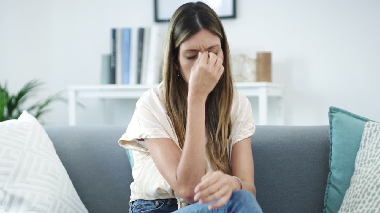 mujer sentada en el sofá, mirando infeliz