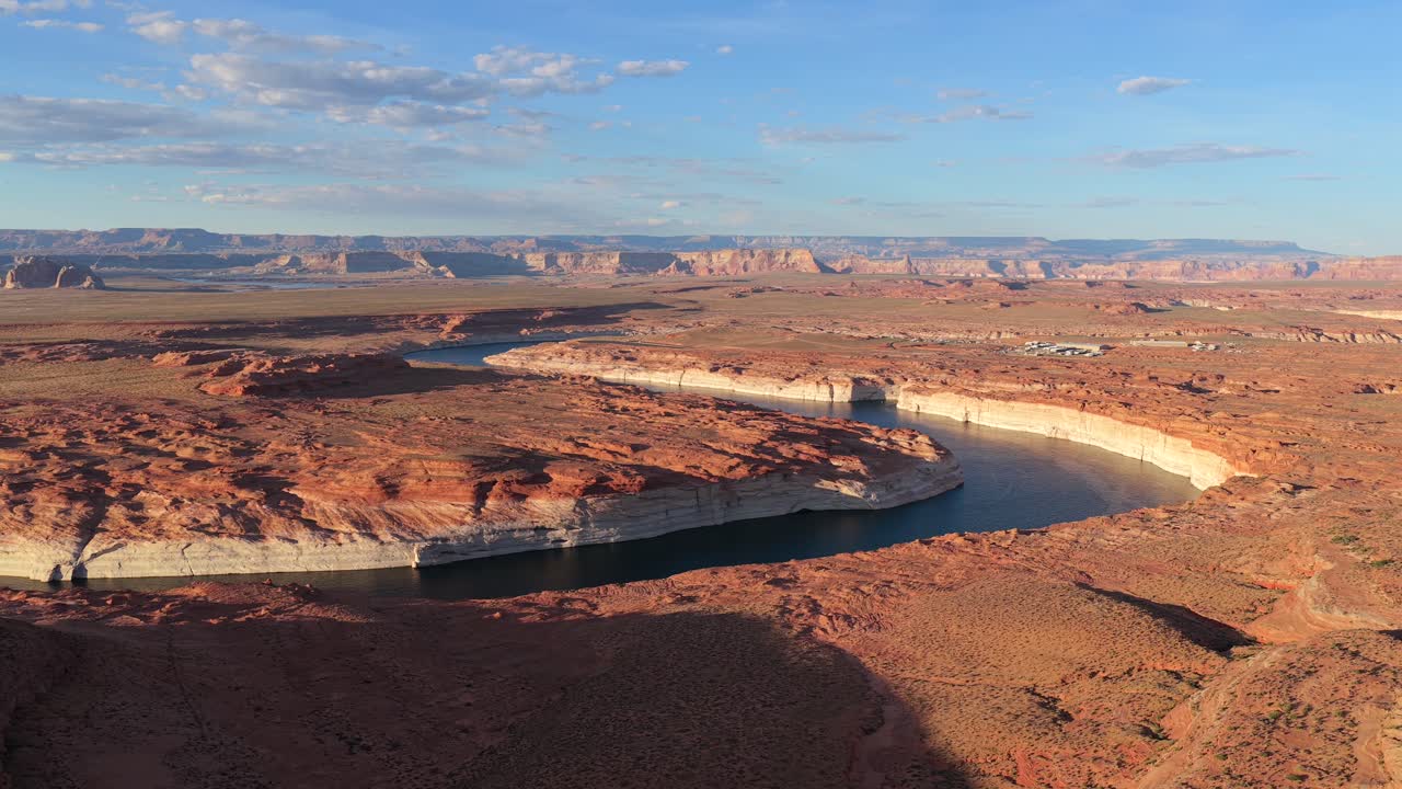 Questa prospettiva da drone rivela un profondo fiume nel canyon che attraversa aspre formazioni rocciose rosse. L'ampia vista desertica evidenzia la scala epica e la bellezza naturale del paesaggio arido.