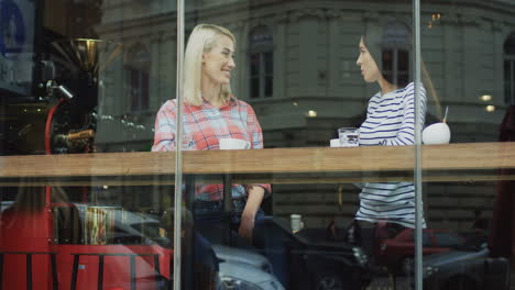 two attractive women talking, laughing and hugging