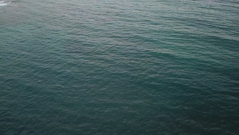 Extended-drone-shot-of-ocean-water-at-sunset