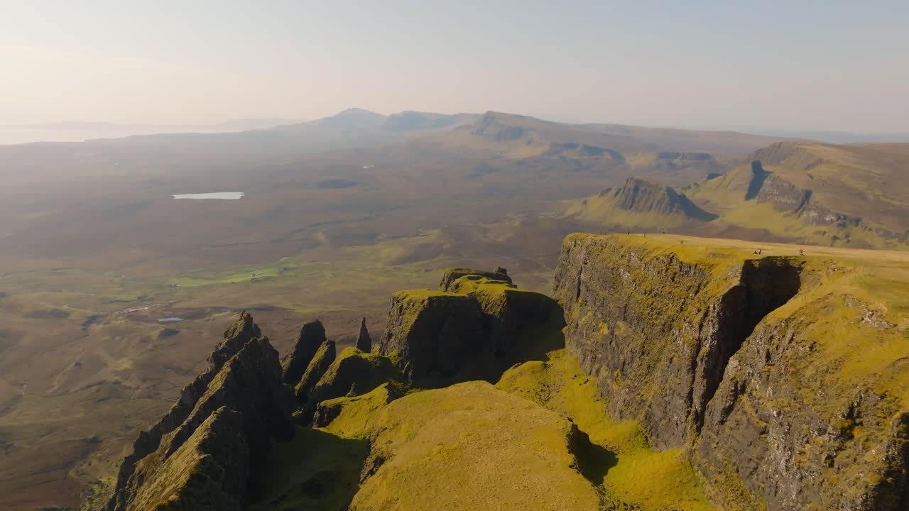 Aerial drone footage of the dramatic mountain landscapes on the Isle of Skye, Scotland. Sweeping panoramic views of majestic peaks, green valleys, and wild nature. Quiraing walk