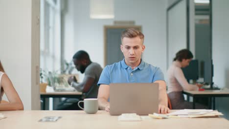 Upset-man-looking-at-laptop-computer-at-workplace.-Shocked-man-reading-news