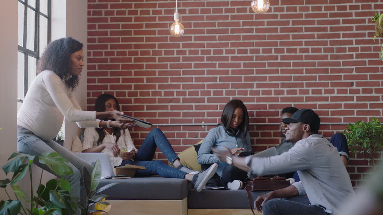 jóvenes empresarios negros se reúnen para una lluvia de ideas gerente embarazada mujer presentando ideas de proyectos usando computadoras tablet entrenando colegas colaborando discutiendo la solución en la presentación de la oficina