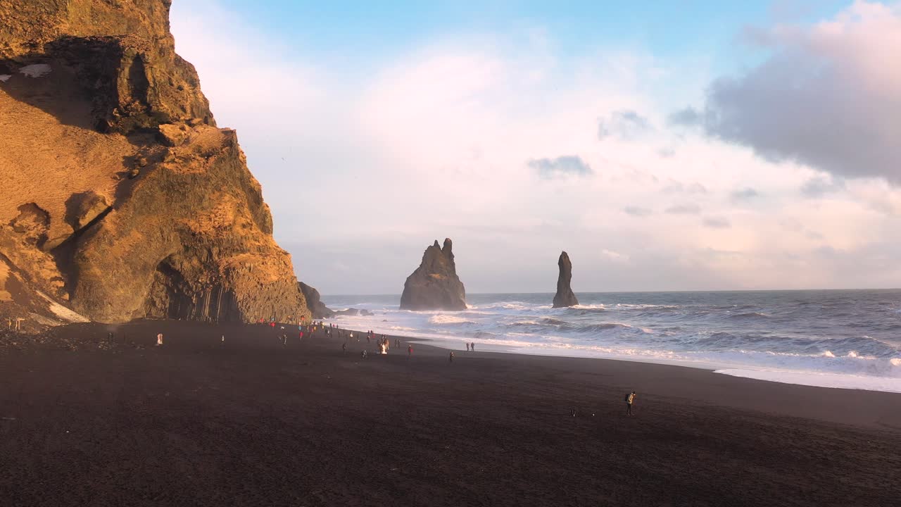 Tranquil Serenity: Aerial Footage of People Wandering Iceland's Black Sand Beach