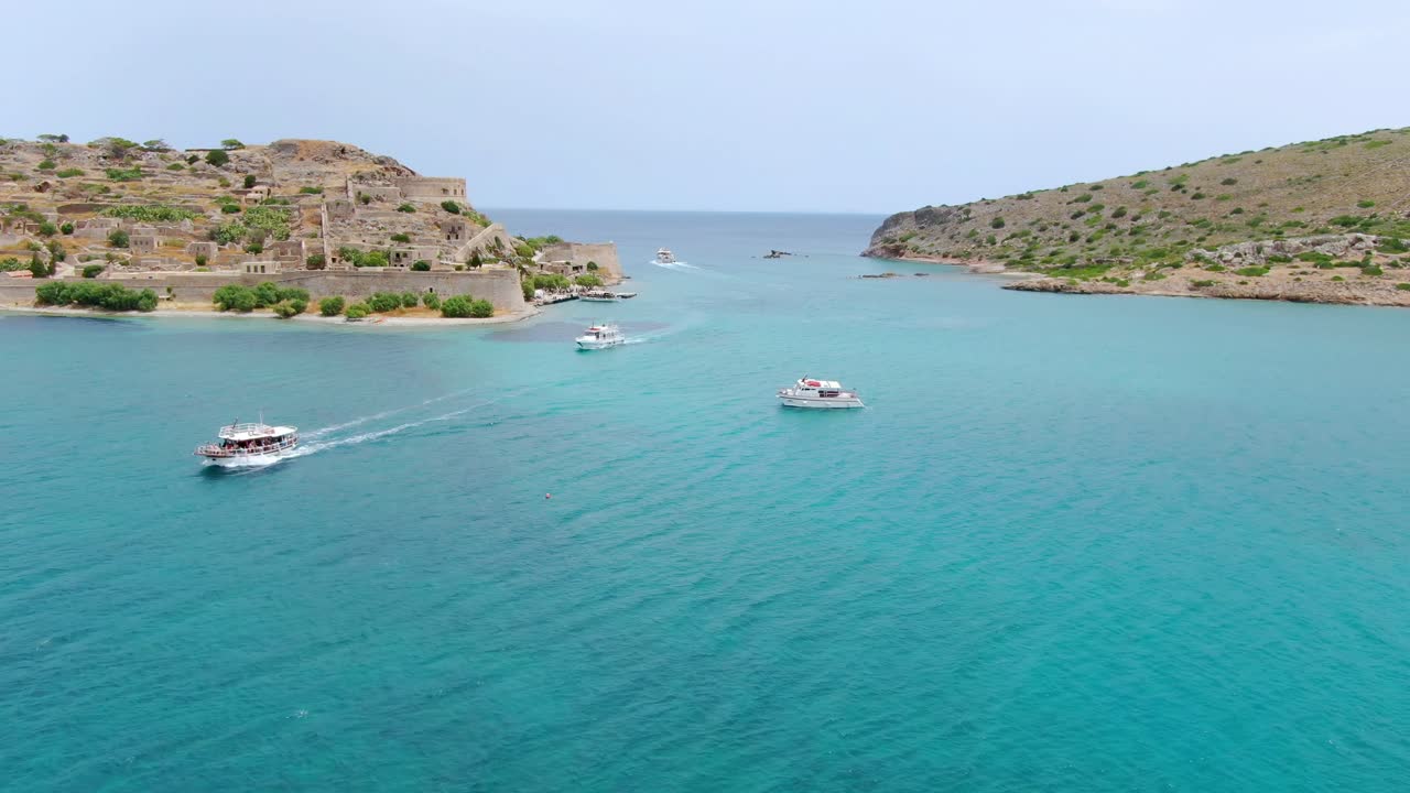 Tourists motorboat nearshore the island of Spinalonga, Gulf of Elounda. Aerial
