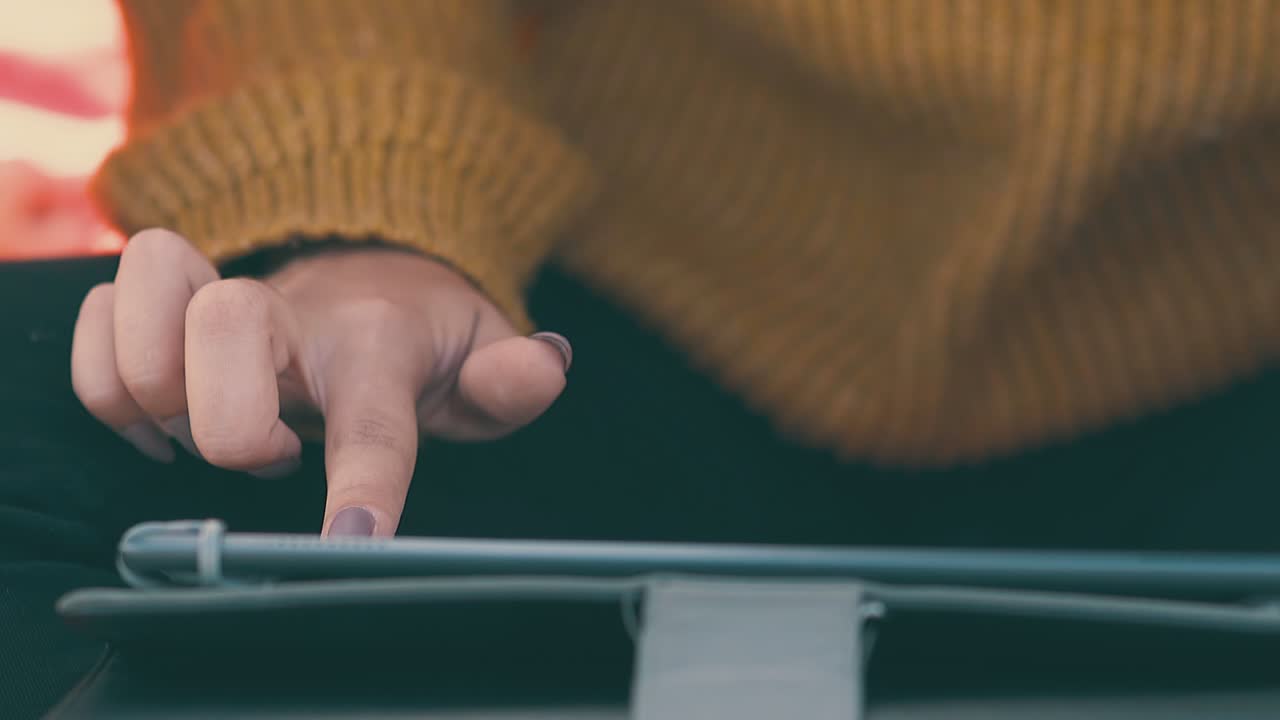 여자 는 아침 의 느린 움직임 으로 초원 에 있는 캠프 에서 태블릿 을 사용 한다