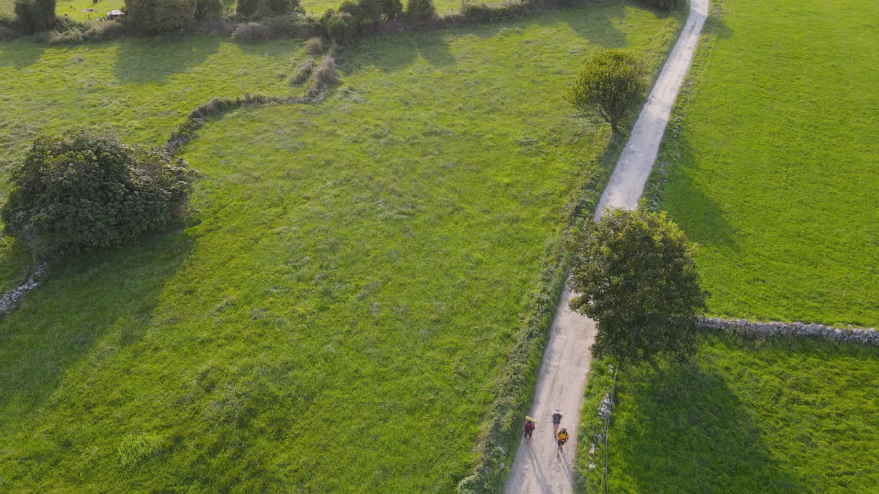 화창한 날 1일 흙길을 함께 걷는 세 명의 순례자 그룹의 공중 전망