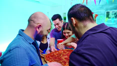 follow shot of young man arriving at the party with delicious pizza