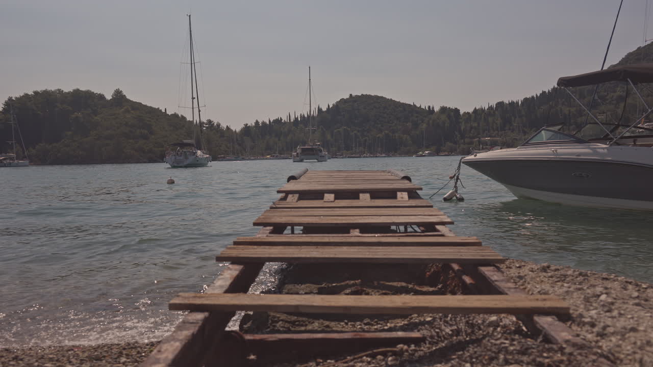 wooden gang plank on beach in nydri port, lefkada greece
