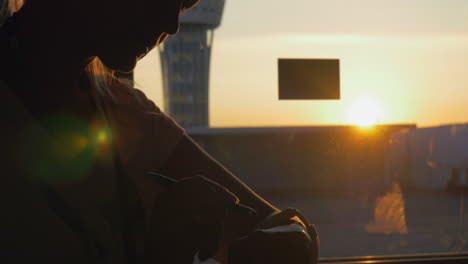 woman with smart watch in airport at sunset