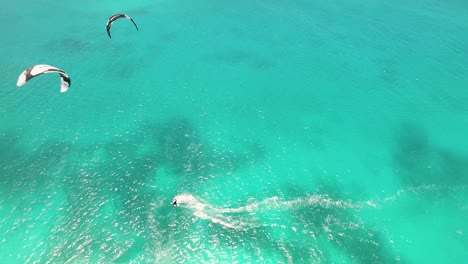 drone shot two men kiteboarders flying opposite each other on kiteboards over the sea, los roques