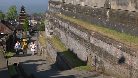 Las-Mujeres-Suben-Empinados-Escalones-De-Piedra-Para-Llevar-Ofrendas-Al-Templo-Besakih-En-Bali,-Indonesia