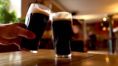 two pints of stout beer clinking together