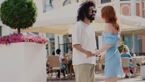 couple holding hands in cafe terrace