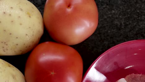 Medium-close-up-pan-around-top-shot-of-meat,-potatoes,-tomatoes,-carrots-and-green-beans